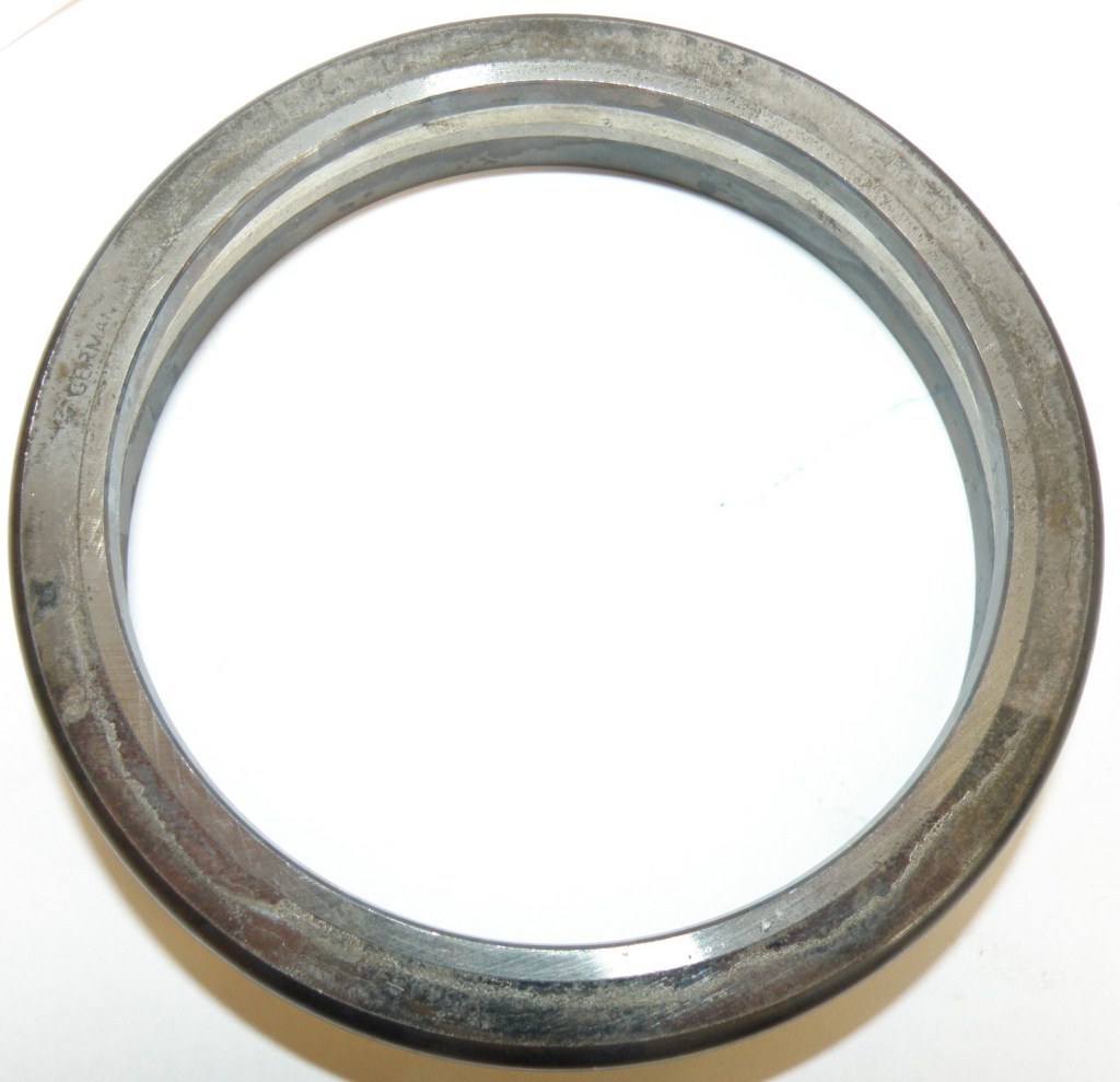 A metal ring with a smooth, shiny surface, featuring a circular shape and a thin profile, commonly used as a component in machinery or mechanical applications.